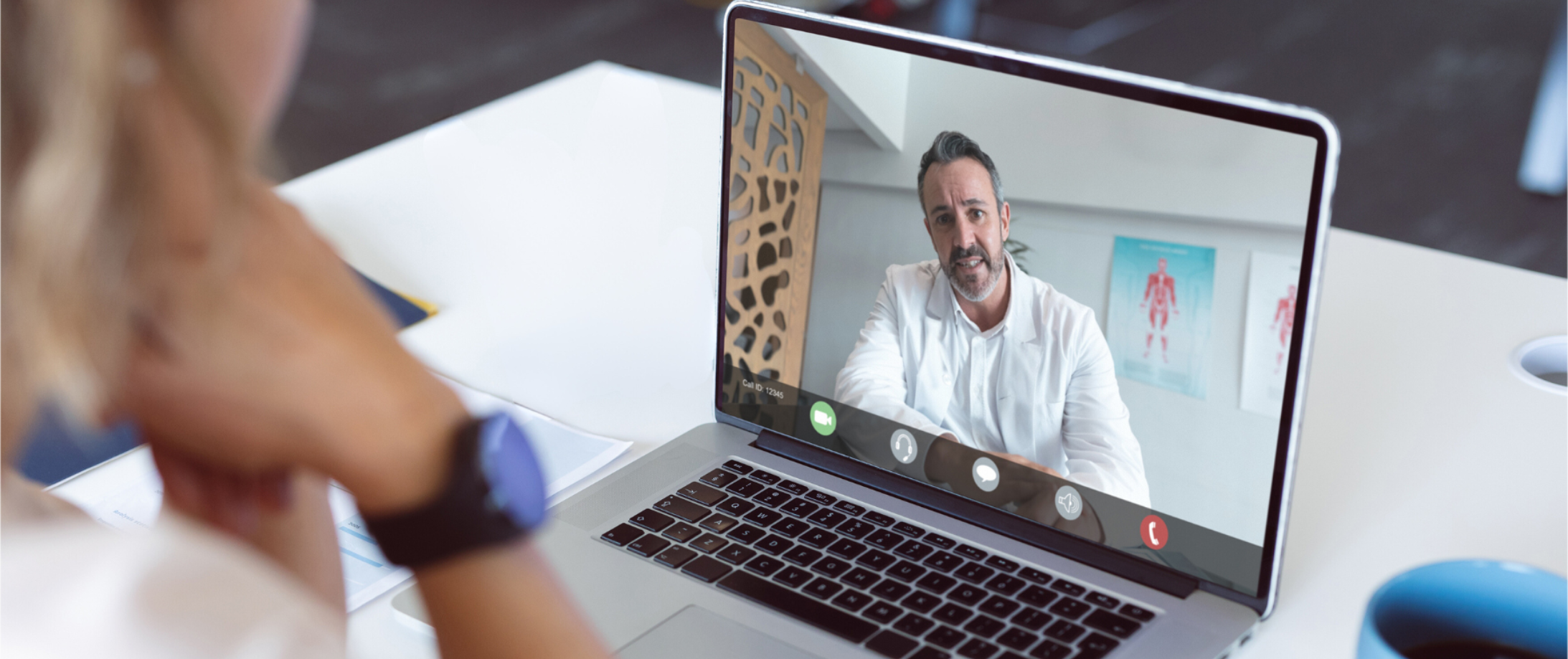 Person watching healthcare professional speaking during a webinar on a laptop